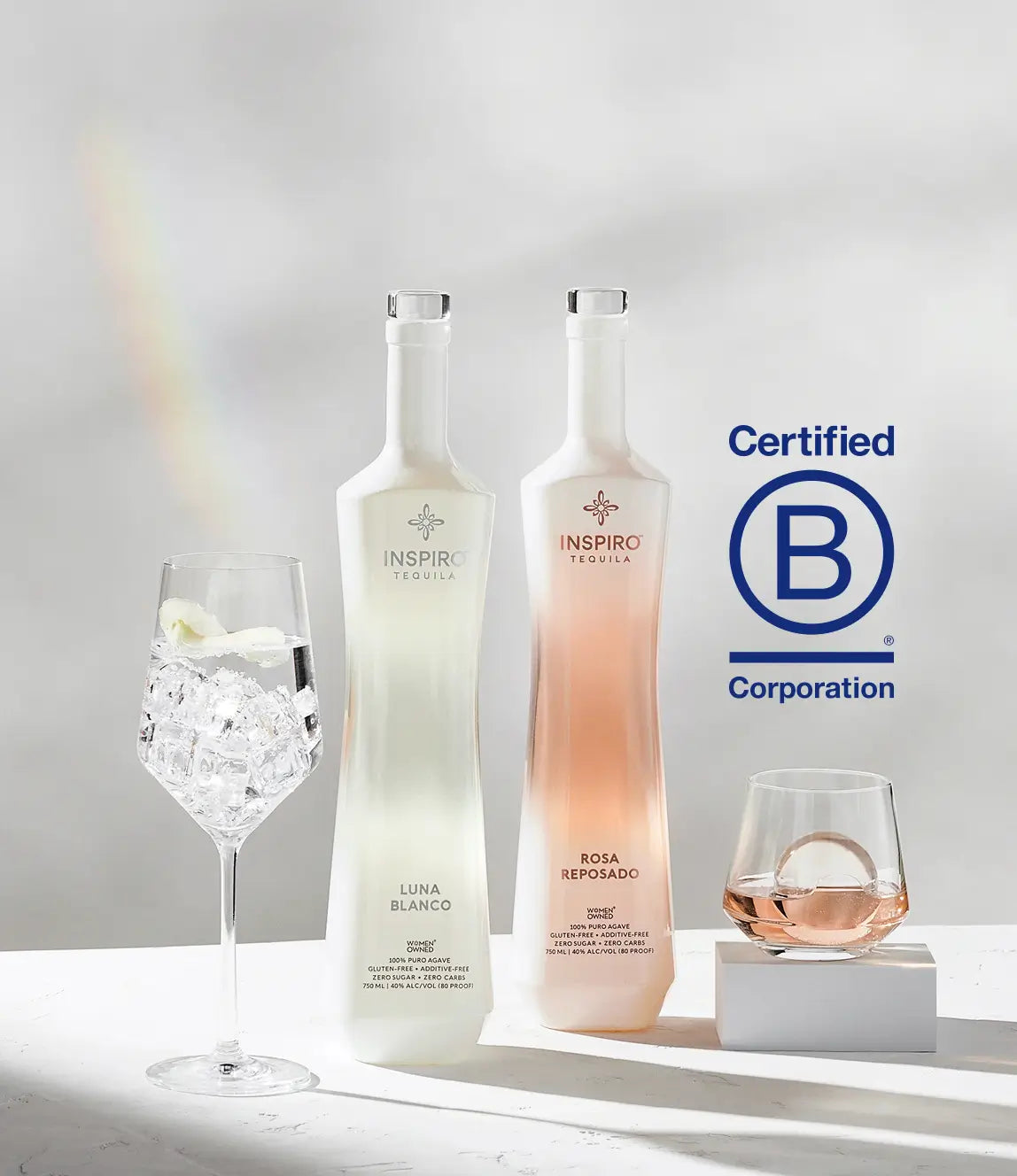 Two bottles of Inspiro Tequila, one labeled 'Luna Blanco' and the other 'Rosa Reposado', with two glasses on a light background. Certified B Corporation logo is visible.